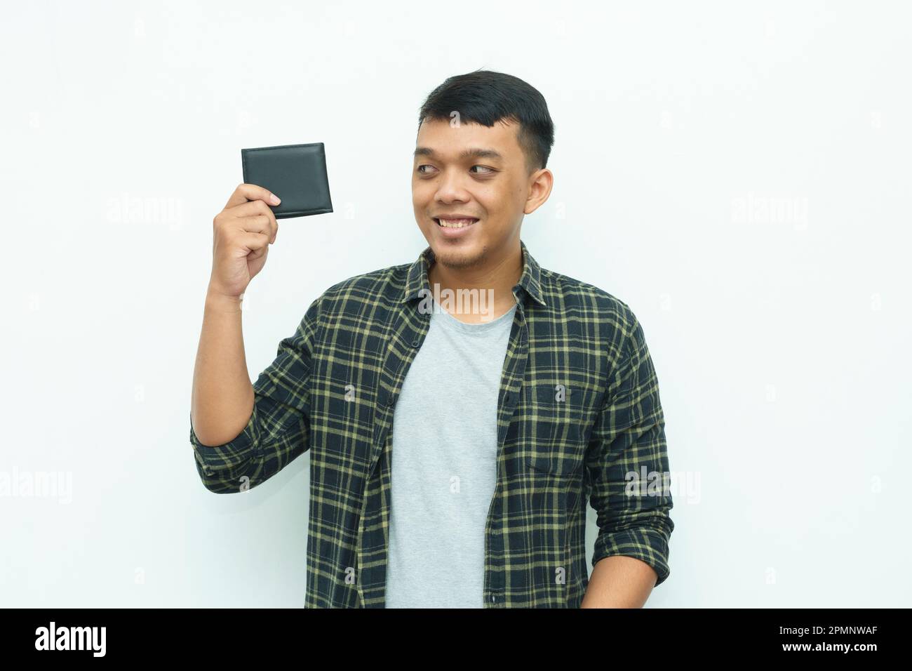 Jeune homme asiatique souriant tout en tenant un portefeuille noir Banque D'Images