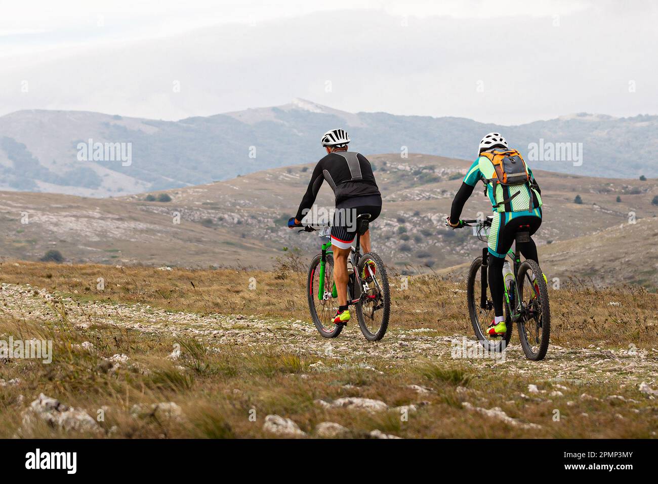deux cyclistes mâles qui font du vélo de montagne sur un plateau de montagne en vélo de fond. sac à dos à l'arrière du vélo tout terrain Banque D'Images