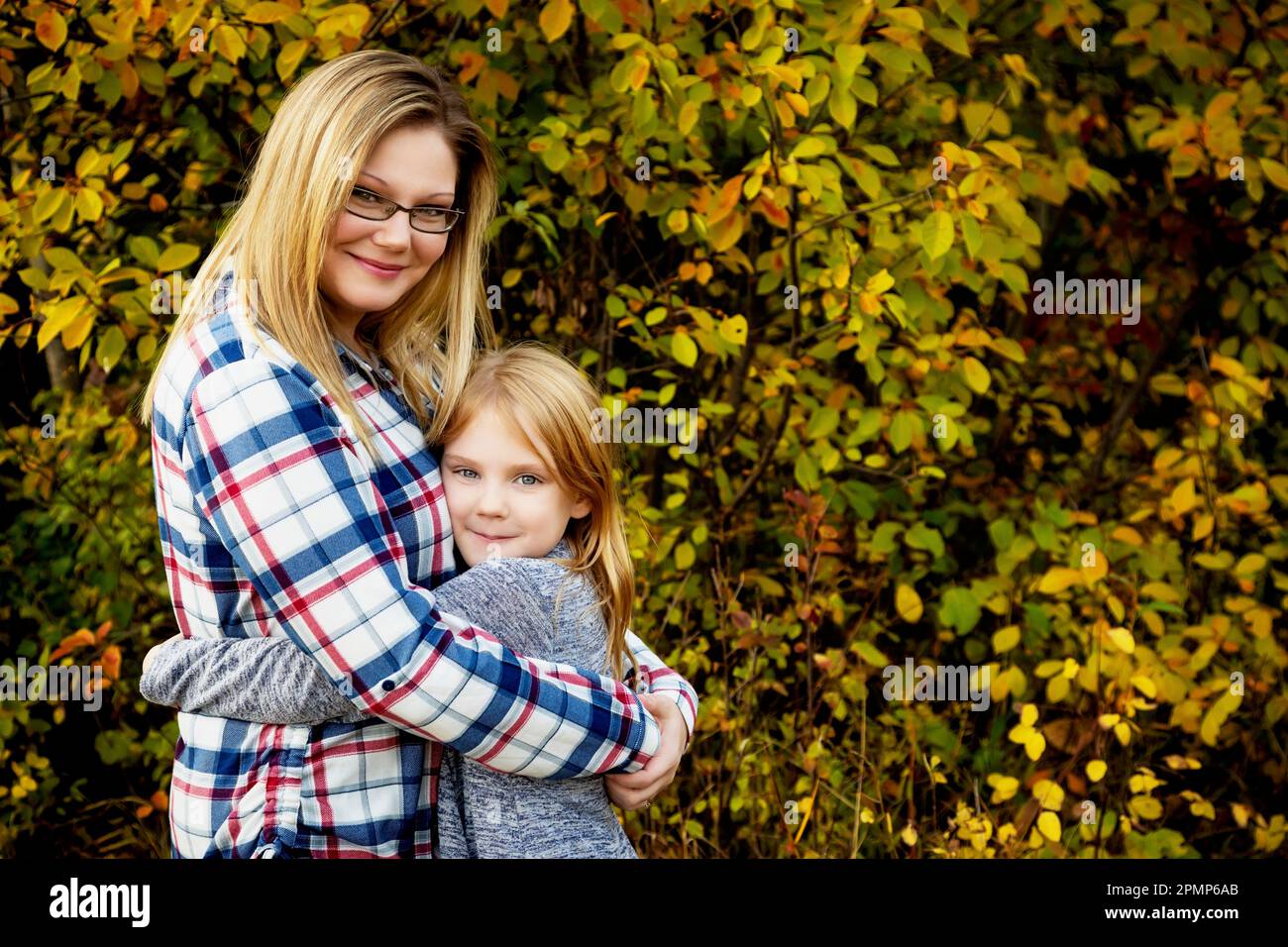 Portrait extérieur d'une mère avec sa fille dans une étreinte; Edmonton, Alberta, Canada Banque D'Images