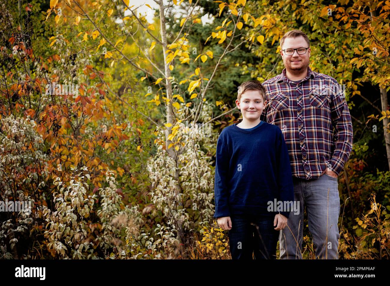 Portrait extérieur d'un père avec son fils à l'extérieur dans un parc en automne; Edmonton, Alberta, Canada Banque D'Images
