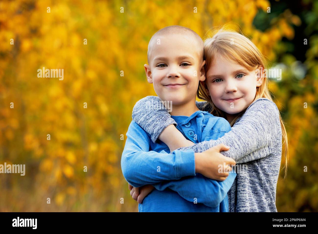 Portrait extérieur d'un frère et d'une sœur dans une étreinte dans un parc en automne; Edmonton, Alberta, Canada Banque D'Images