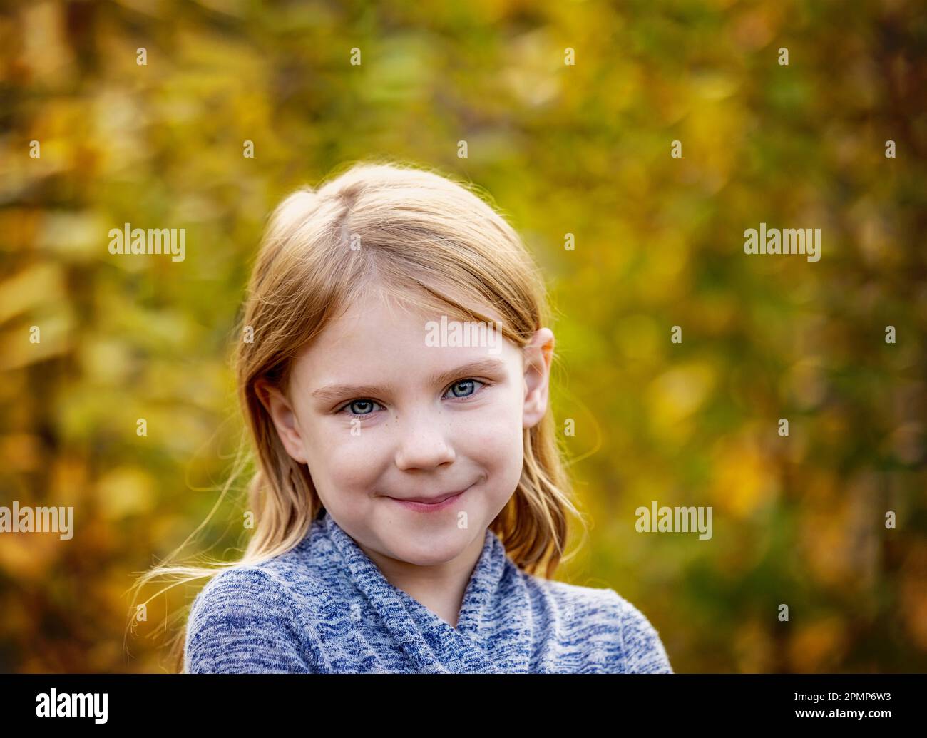 Portrait extérieur d'une fille aux yeux bleus et aux cheveux blonds à l'automne; Edmonton, Alberta, Canada Banque D'Images