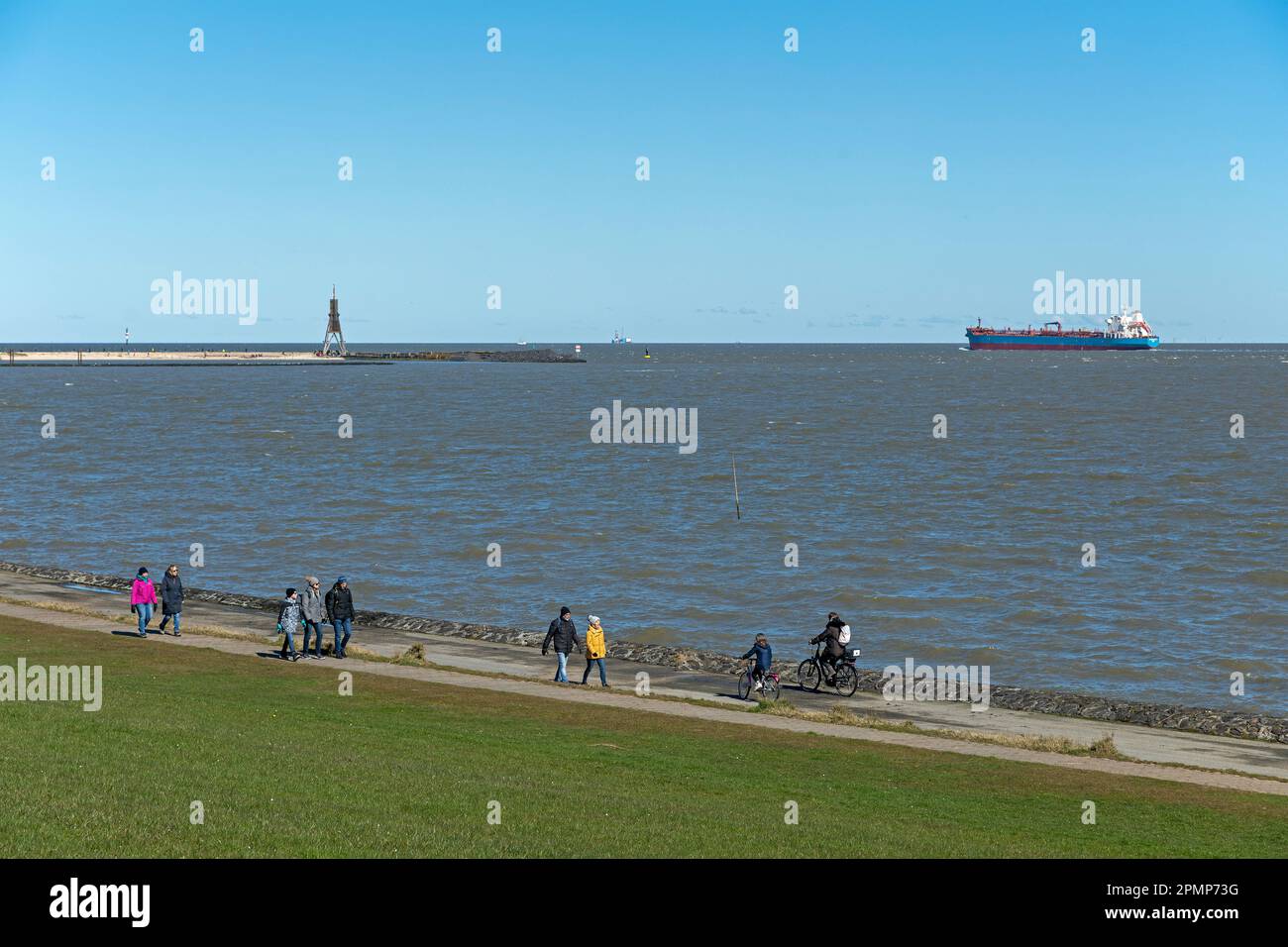 Marqueur de mer Kugelbake, cyclistes, randonneurs, navire à conteneurs, Grimmershörn Bay, Cuxhaven, Basse-Saxe, Allemagne Banque D'Images