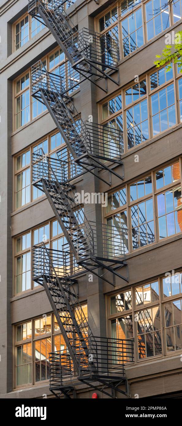 Escaliers de secours montés à l'extérieur du Western Building dans le centre-ville de Seattle, Washington, avec des reflets dans les fenêtres Banque D'Images
