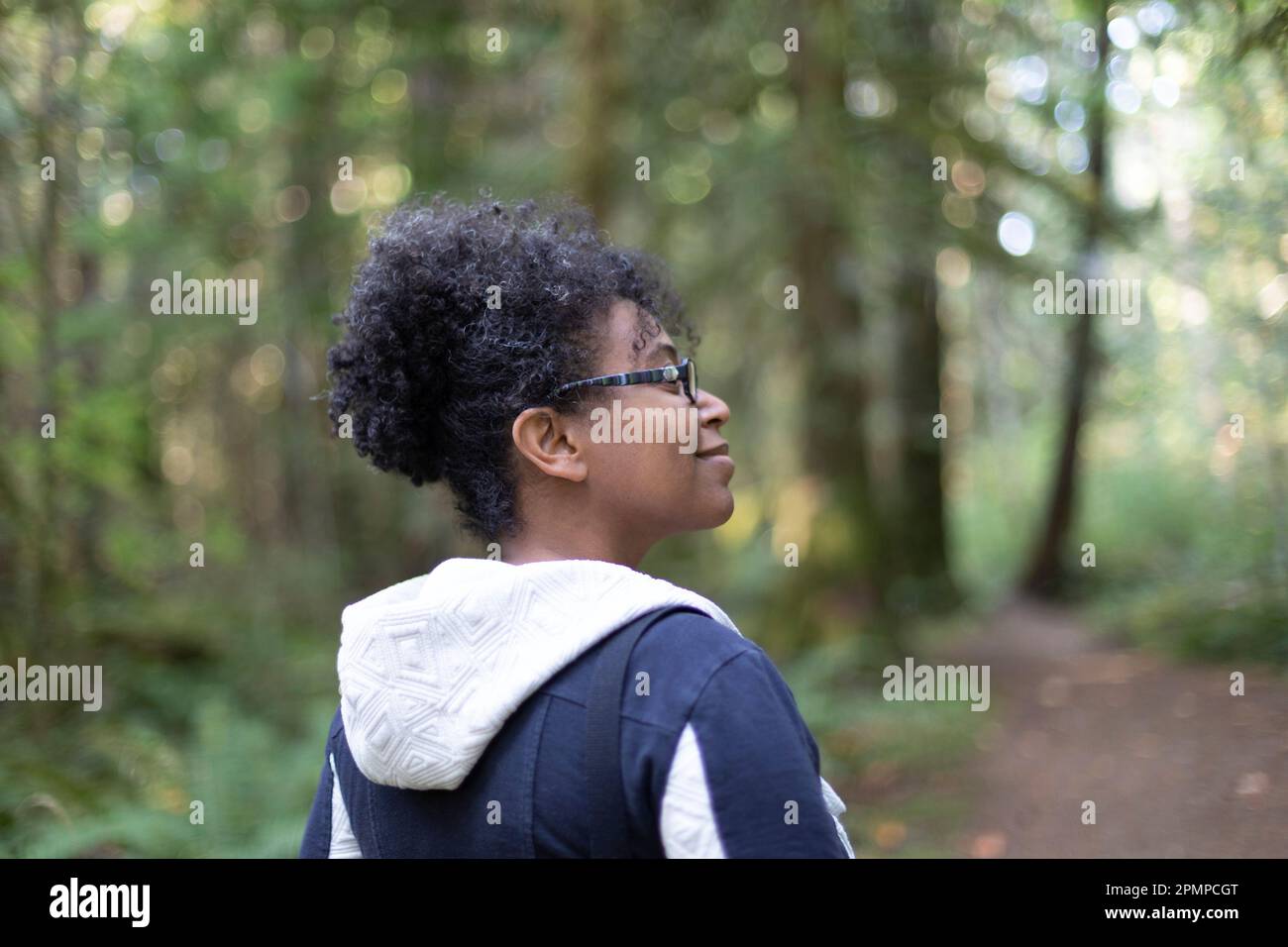 Femme à l'extérieur appréciant la nature en souriant le long d'un sentier boisé dans le parc provincial de Stamp River; Port Alberni, Colombie-Britannique, Canada Banque D'Images