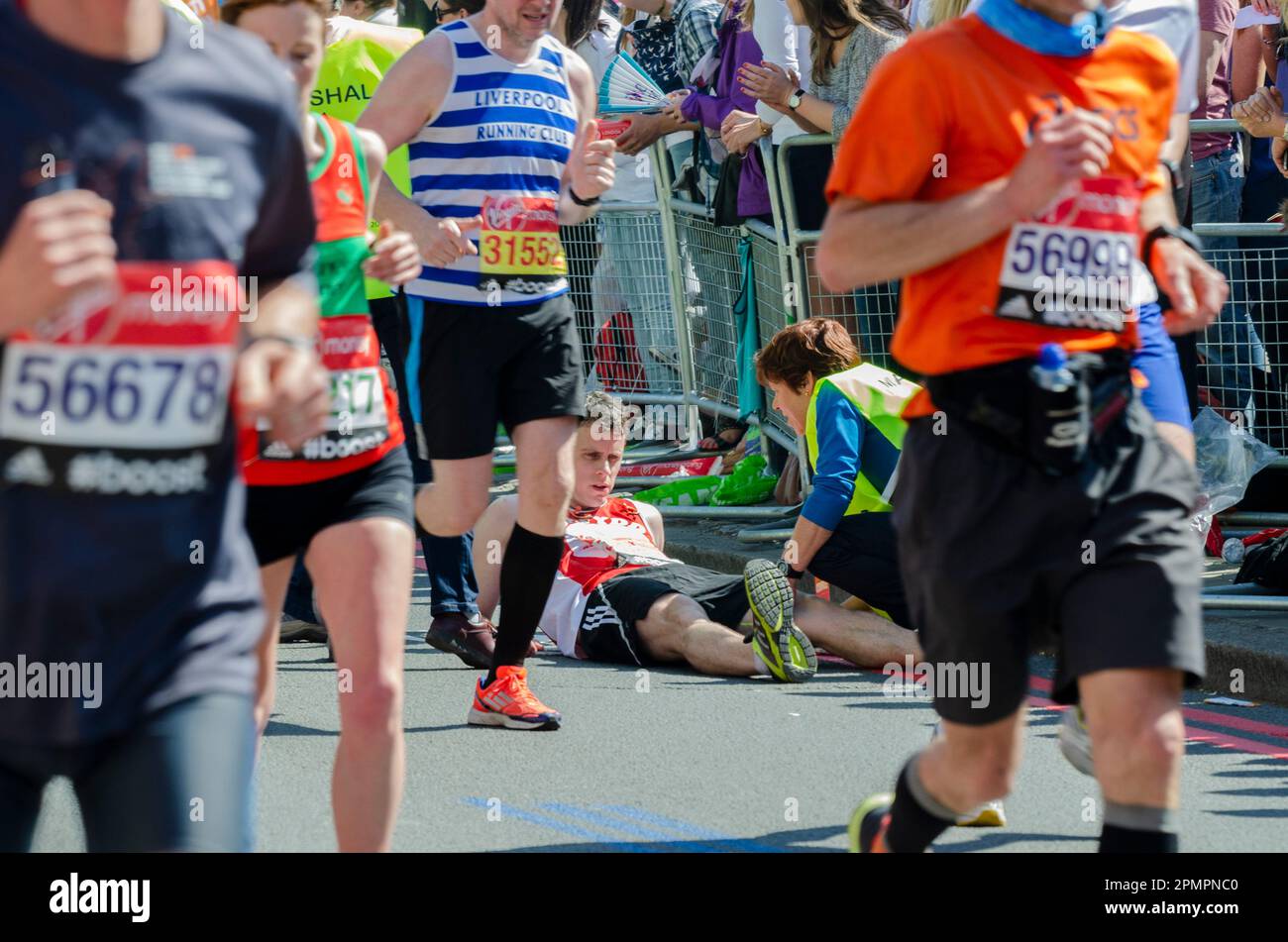Coureur souffrant du marathon de Londres 2014, passant par Tower Hill près de la Tour de Londres, Royaume-Uni. Aide du maréchal Banque D'Images