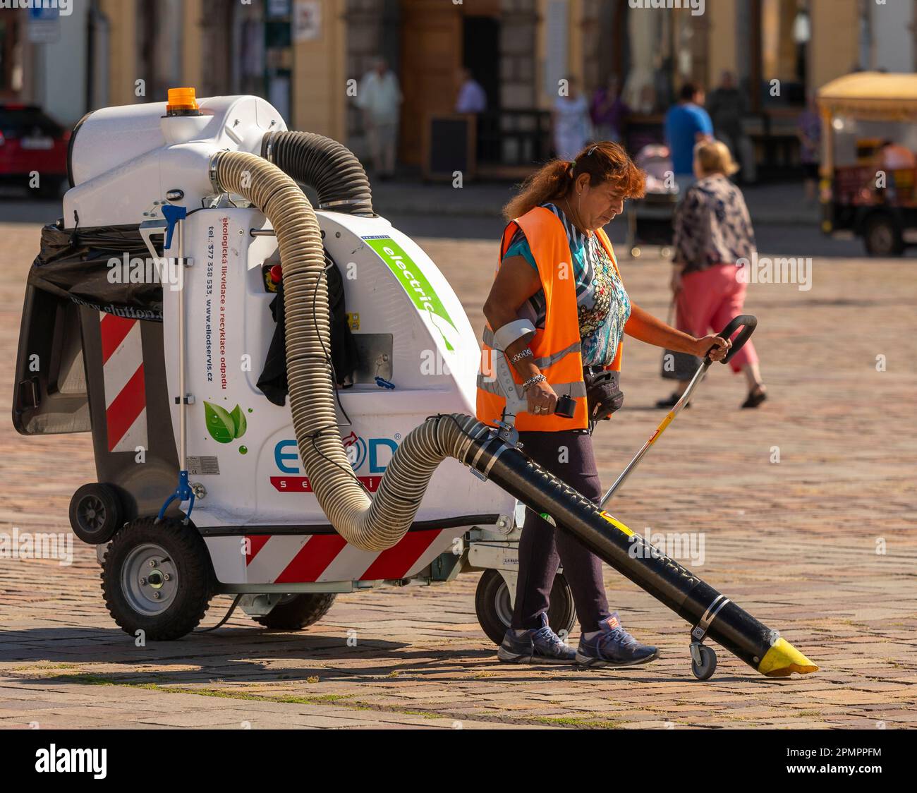 PILSEN, RÉPUBLIQUE TCHÈQUE, EUROPE - un travailleur sanitaire municipal nettoie la place principale de Pilsen avec un chariot à vide. Namesti Republiky Plzen. Banque D'Images