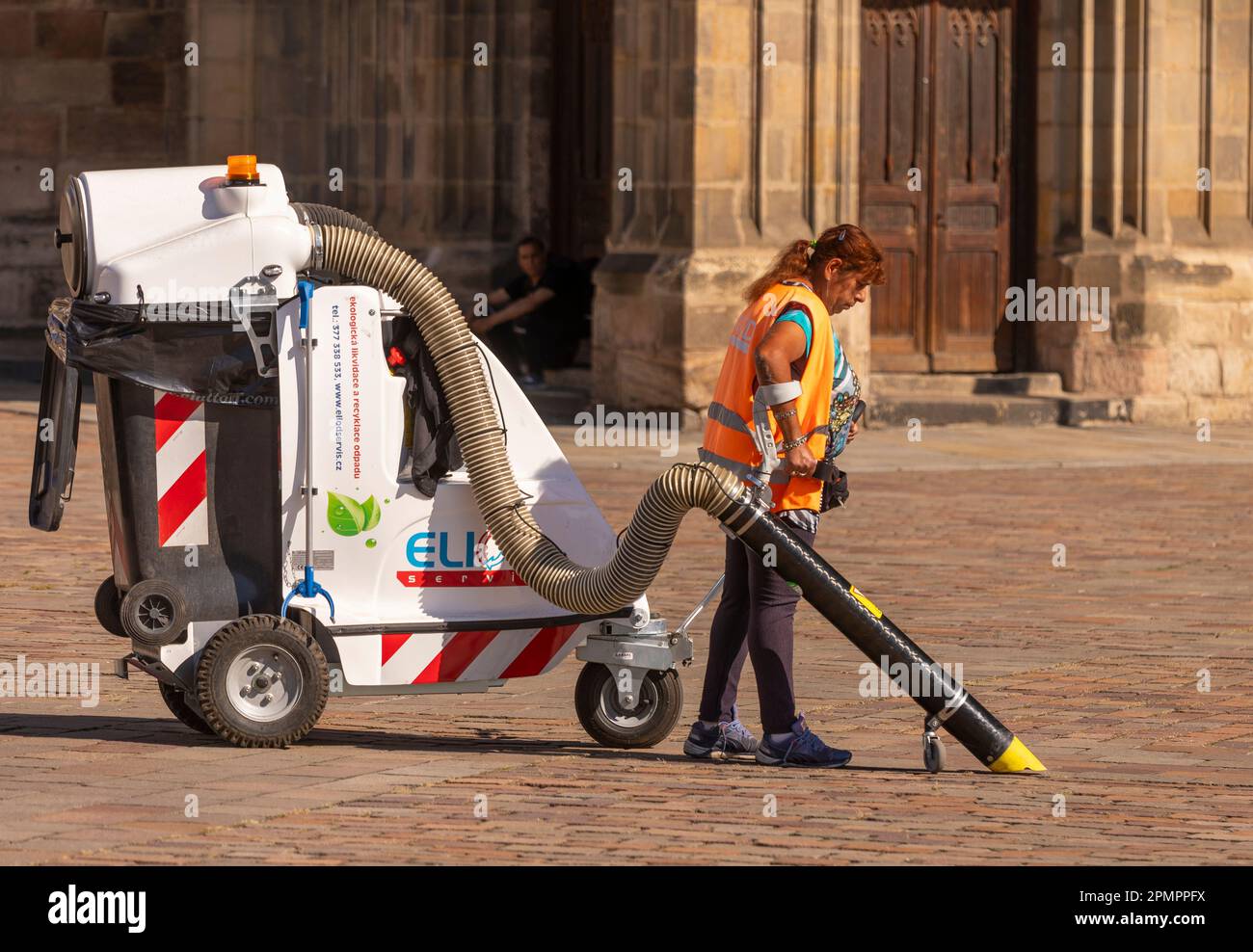 PILSEN, RÉPUBLIQUE TCHÈQUE, EUROPE - un travailleur sanitaire municipal nettoie la place principale de Pilsen avec un chariot à vide. Namesti Republiky Plzen. Banque D'Images