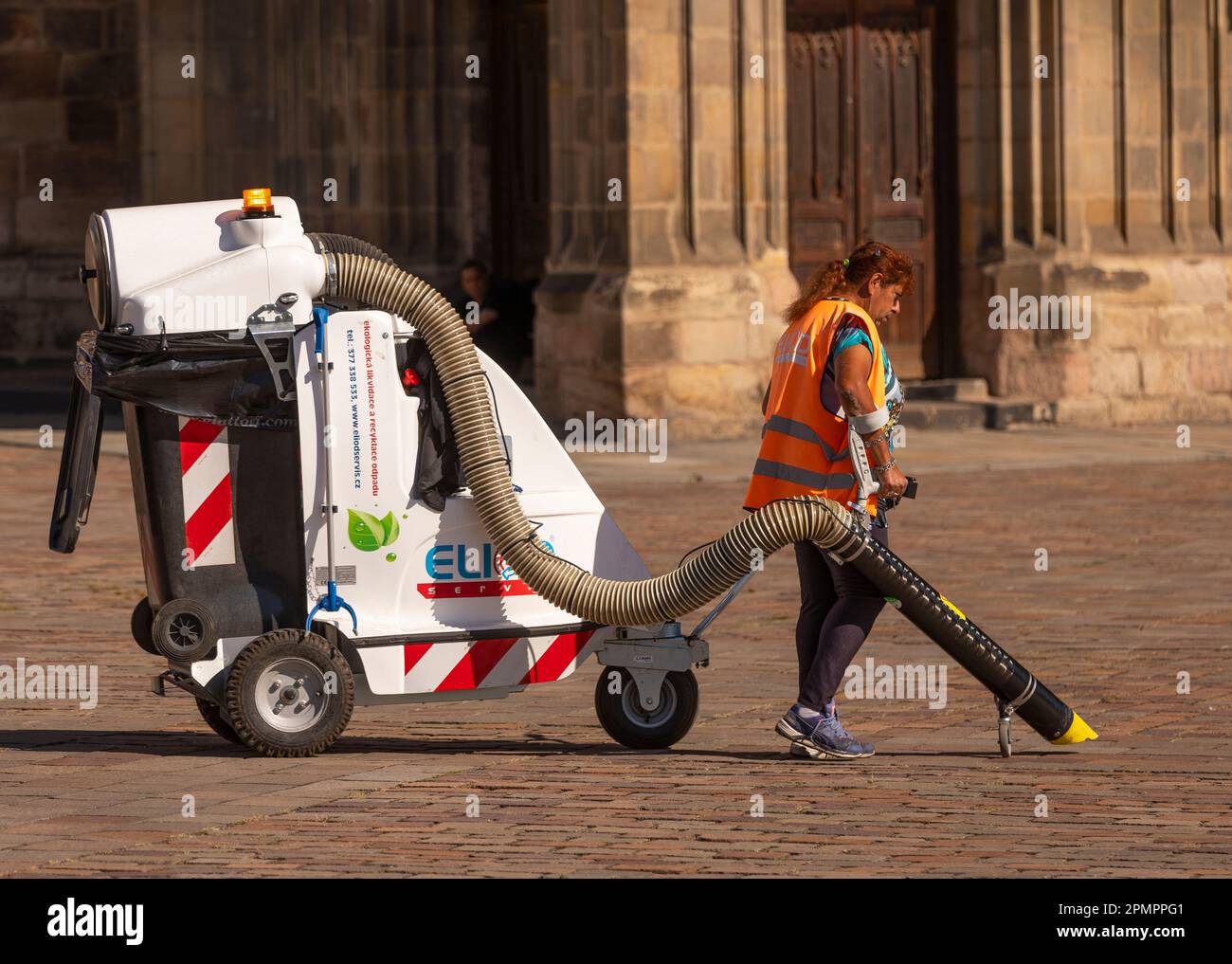 PILSEN, RÉPUBLIQUE TCHÈQUE, EUROPE - un travailleur sanitaire municipal nettoie la place principale de Pilsen avec un chariot à vide. Namesti Republiky Plzen. Banque D'Images