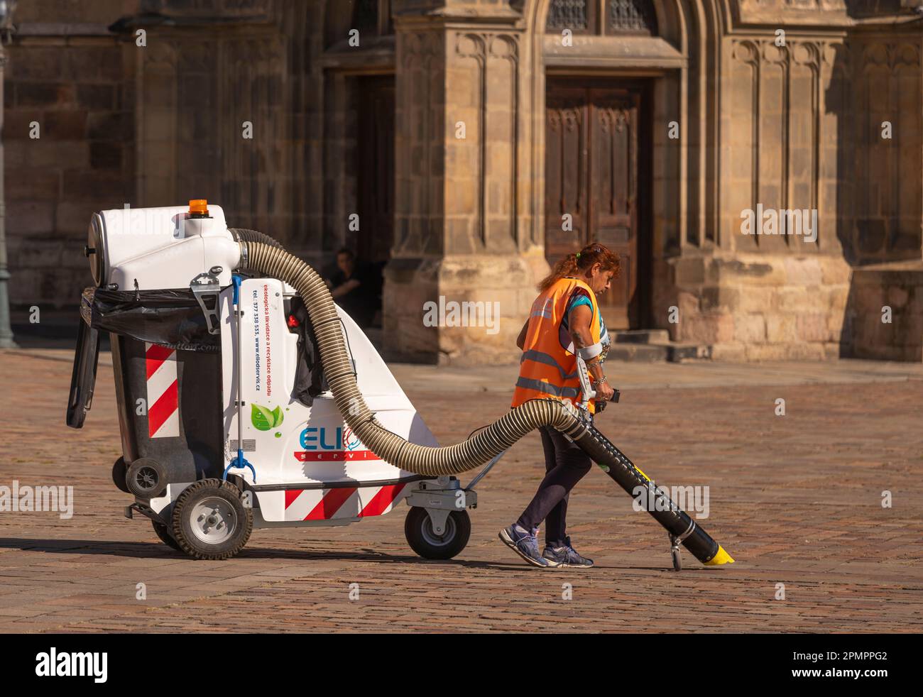 PILSEN, RÉPUBLIQUE TCHÈQUE, EUROPE - un travailleur sanitaire municipal nettoie la place principale de Pilsen avec un chariot à vide. Namesti Republiky Plzen. Banque D'Images