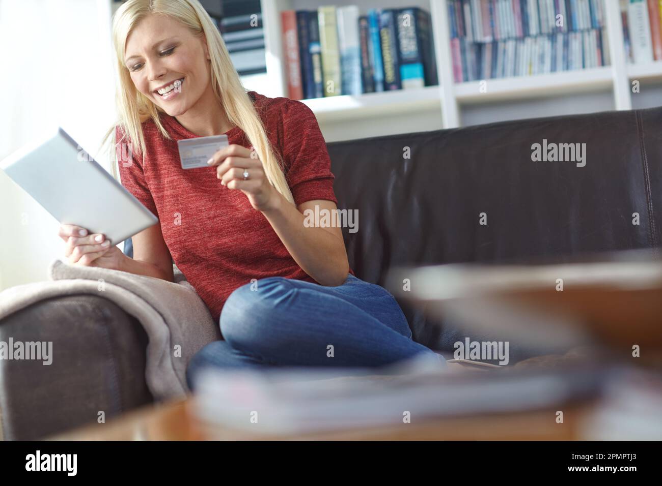 Faire du shopping dans le confort de la maison. une jeune femme attirante utilisant sa tablette numérique pour faire des achats en ligne. Banque D'Images