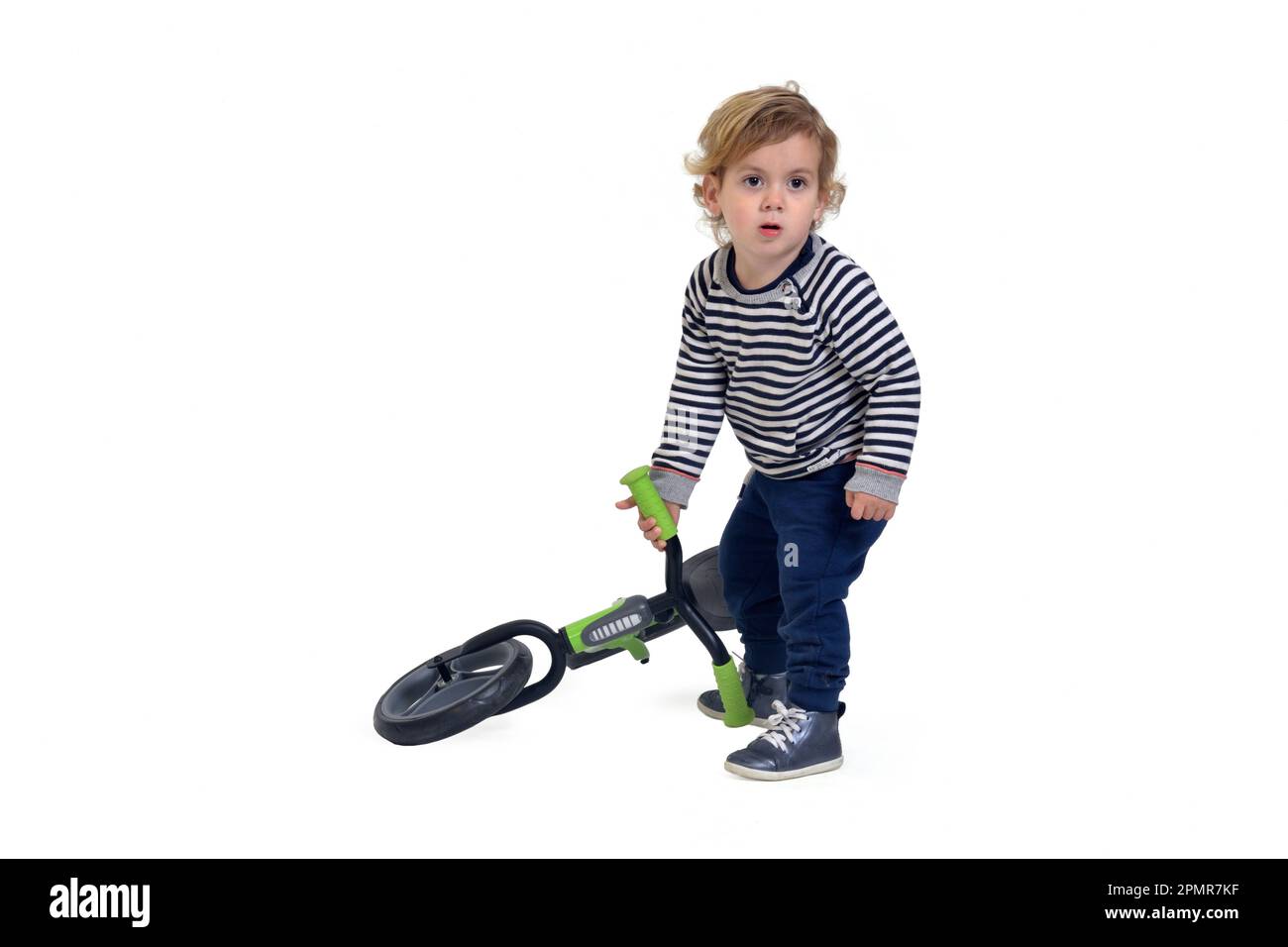 bébé lève le vélo du sol sur fond blanc Banque D'Images