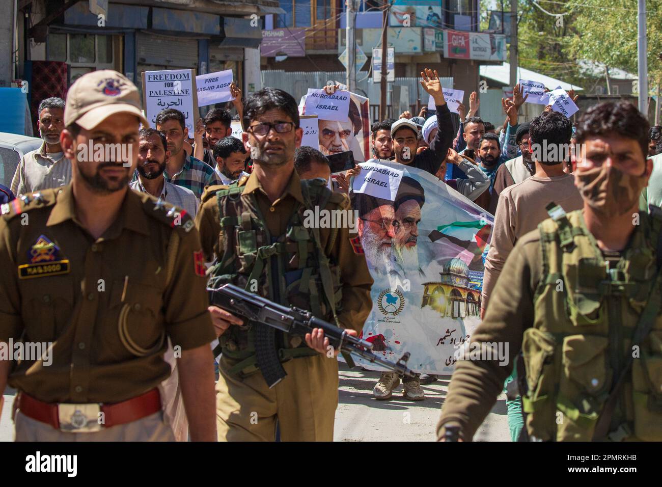 Les policiers indiens sont en garde tandis que les musulmans cachemiriens tiennent des placardes le jour d'Al Qods, scandant des slogans pro-palestiniens, anti-israéliens et américains après que les forces d'occupation israéliennes aient pris d'assaut la mosquée Al Aqsa, le troisième lieu sacré de Jérusalem-est à la suite de raids brutaux lors des prières du Ramadan. Des centaines de Palestiniens ont été blessés et détenus malgré des condamnations du monde arabe et musulman.lors d'un rassemblement marquant le jour d'al-Quds (jour de Jérusalem) à Srinagar. (Al-Qud) est le nom arabe de Jérusalem, est un événement annuel pro-palestinien qui a eu lieu le dernier vendredi du Saint jeûne islamique du Ramadan Banque D'Images