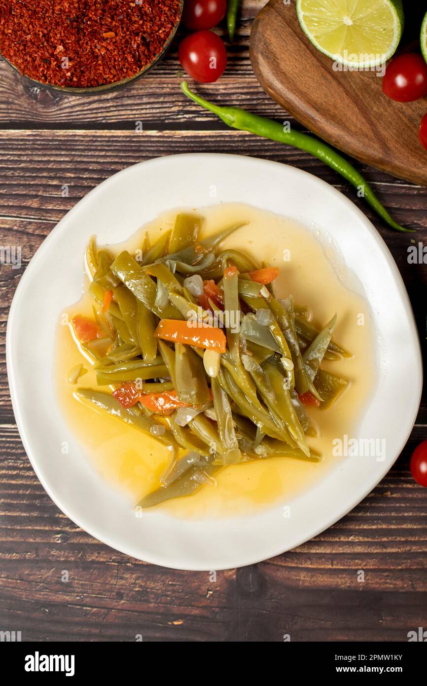 Plat de haricots verts avec huile d'olive sur fond de bois. Vue de dessus Banque D'Images