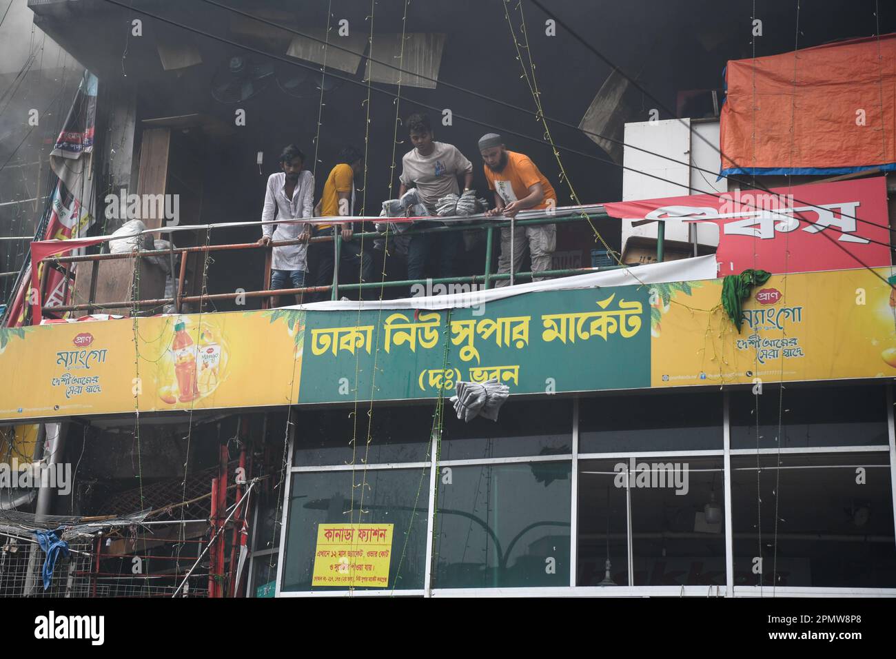 Les propriétaires d'entreprise font sortir leurs biens du site d'un incendie sur le marché de l'habillement à Dhaka. Un grand incendie a ravagé des milliers de magasins sur un marché populaire de l'habillement dans la capitale bangladaise, Dhaka, où les propriétaires de magasins ont été dévastés par les pertes des semaines précédant l'Eid, le festival musulman marquant la fin du Ramadan. Des centaines de pompiers et de militaires ont lutté contre l'inferno alors qu'il a déchiré le marché de l'habillement, en le transformant en une pile de cendres. Plusieurs personnes ont été blessées, mais aucun décès n'a été signalé jusqu'à présent. Les autorités tentaient toujours de déterminer la cause du feu. (Photo de Piy Banque D'Images