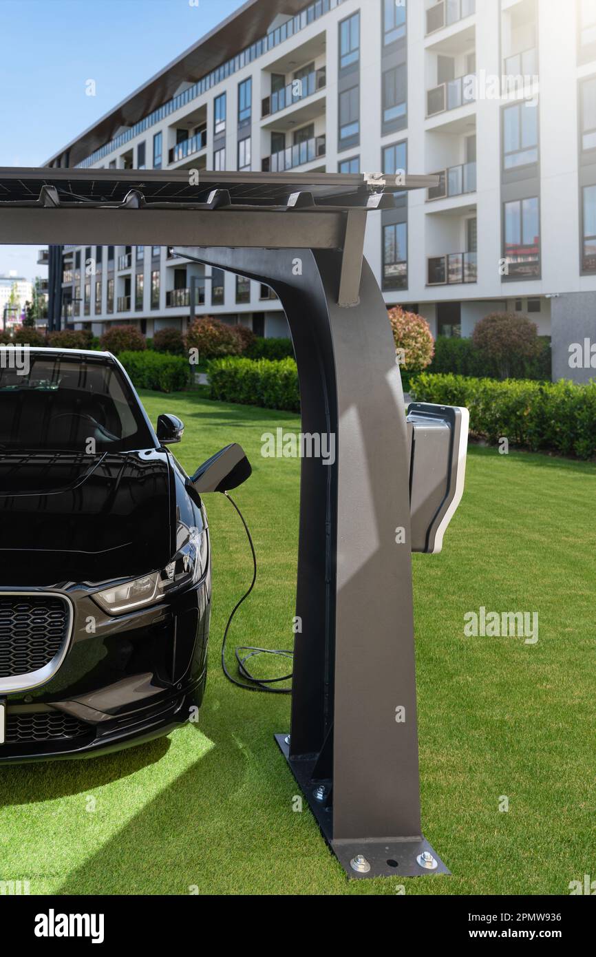 La voiture électrique est chargée à partir d'une station de charge qui prend l'énergie des panneaux solaires. Photo de haute qualité Banque D'Images