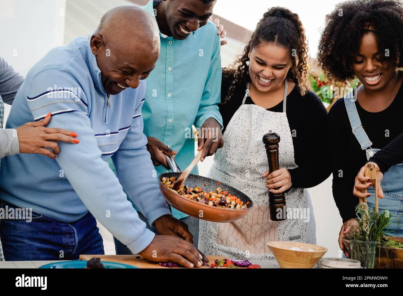 Cuisine extérieure: Bonne famille africaine cuisiner ensemble dans le patio - Père, mère, fille, frère faire des repas sains dîner Banque D'Images