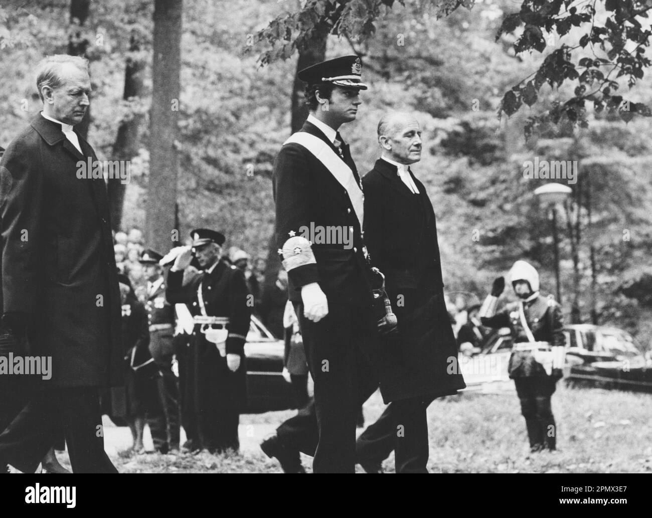 Carl XVI Gustaf, roi de Suède. Né le 30 avril 1946. Photo le 25 septembre 1973 aux funérailles de son grand-père, le roi Gustaf VI Adolf. Photo prise au parc royal Haga avec le roi marchant entre l'archevêque Olof Sundby et le prêtre Hans Åkerhielm. Banque D'Images