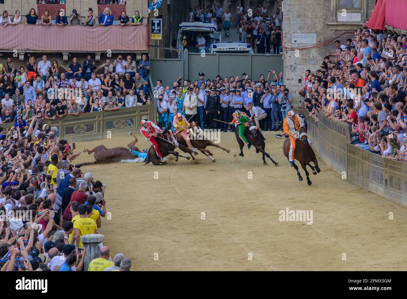 Sienne, Italie - 17 août 2022: Course de chevaux de Palio di Siena à la courbe de Del Casato avec chute de cheval. Banque D'Images