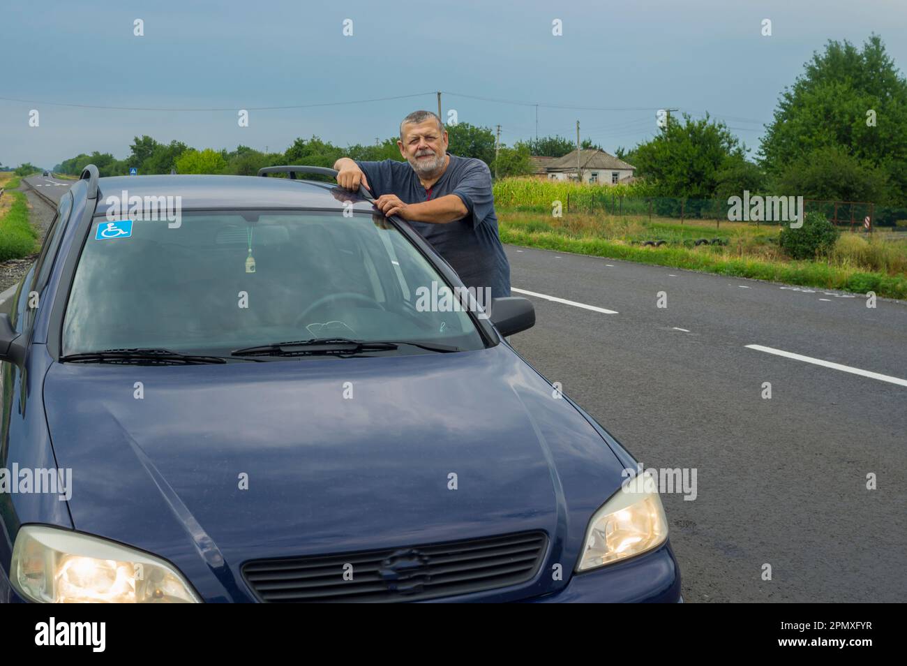 Un snior à barbe ukrainienne se tenant près de sa voiture sur l'autoroute dnipro-poltava tout en se déportant Banque D'Images