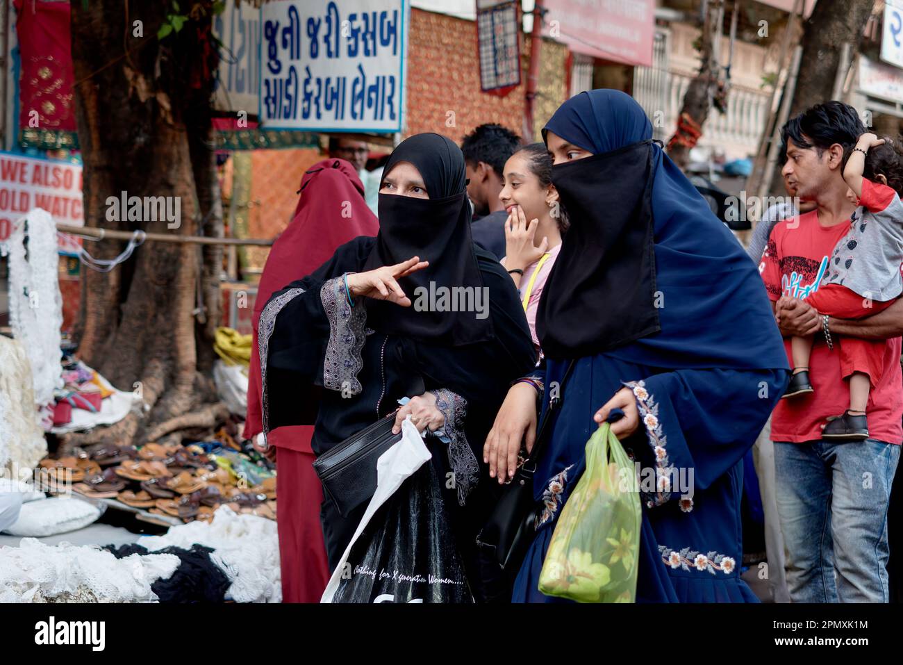 Deux musulmanes voilées et à lit noir magasinent dans un marché de la région de Pydhonie, à majorité musulmane, à Mumbai, en Inde Banque D'Images