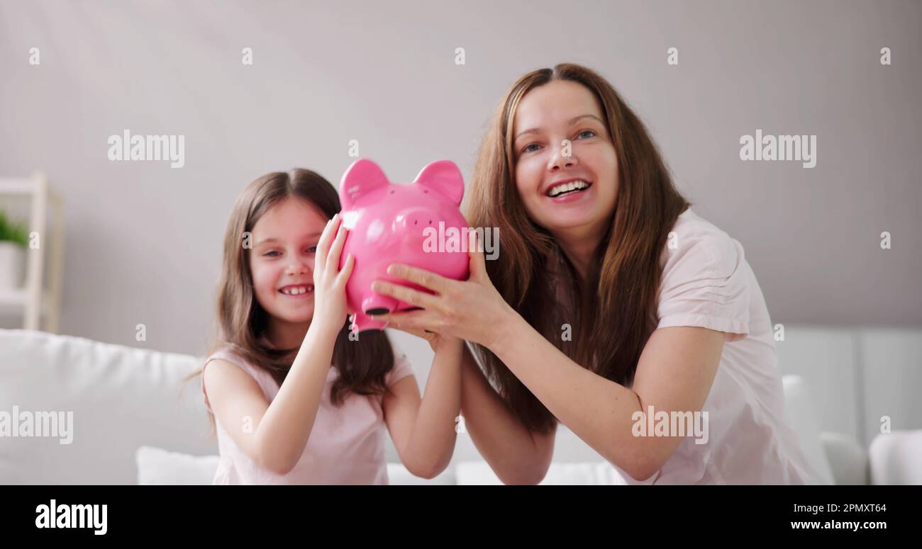 La mère et l'enfant économisent de l'argent avec Piggy Bank Banque D'Images