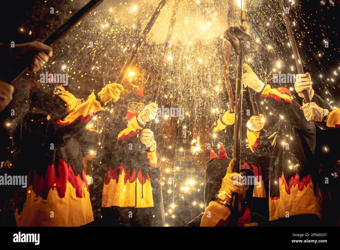 Barcelone, Espagne. 15th avril 2023. Les coureurs de feu en costumes de diable se rassemblent pour éclairer leurs pétards montés sur bâton pendant les 'Correcoss' à la 'Fiesta Major' de la Sagrada Familia. Credit: Matthias Oesterle/Alamy Live News Banque D'Images