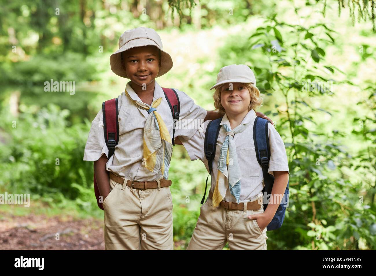 Portrait de deux adorables scouts de garçon regardant l'appareil photo à l'extérieur dans la forêt tout en appréciant le voyage sur le terrain Banque D'Images