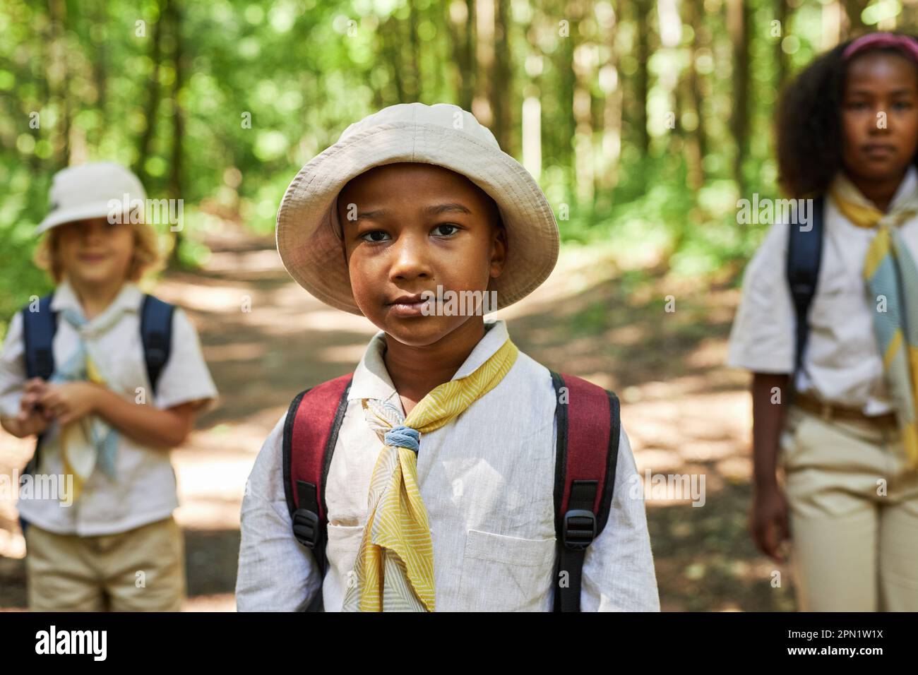 Portrait de jeune garçon noir à la taille en tant que scout de garçon portant uniforme à l'extérieur dans la forêt Banque D'Images