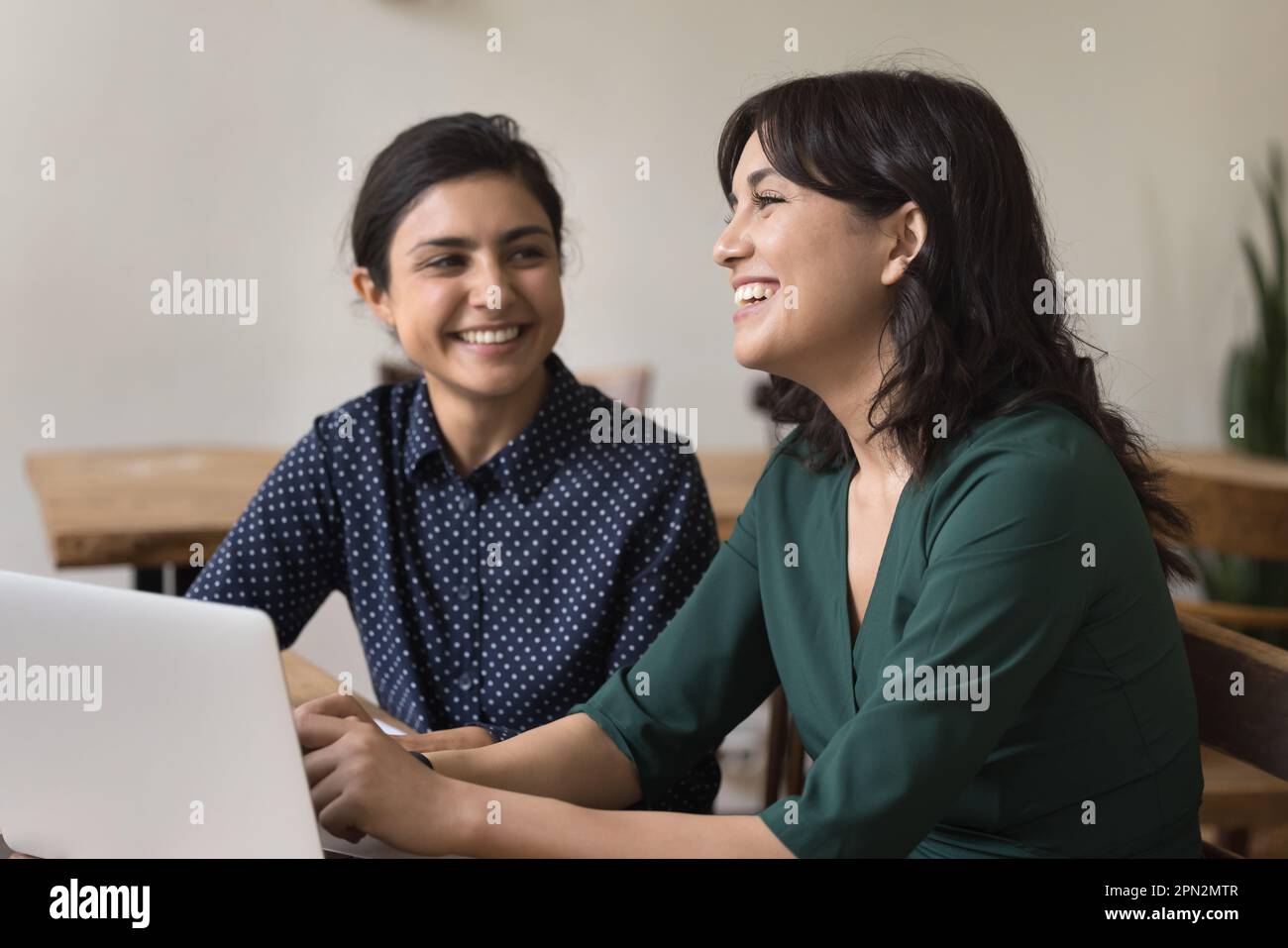 Des femmes indiennes et arméniennes heureuses qui parlent, travaillent ensemble au pouvoir Banque D'Images