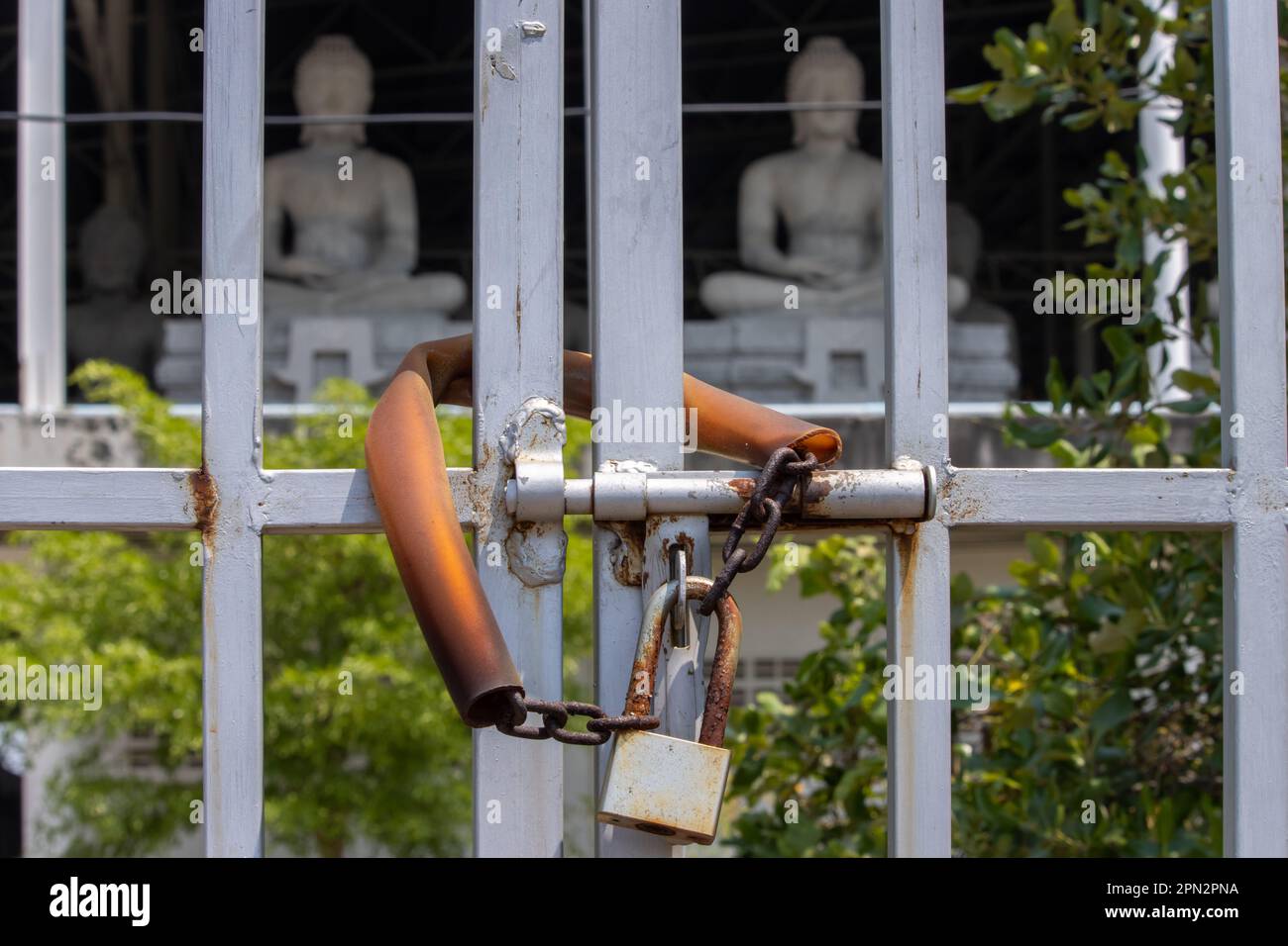 Une porte fermée devant un bâtiment avec des statues de Bouddha assis, Thaïlande Banque D'Images