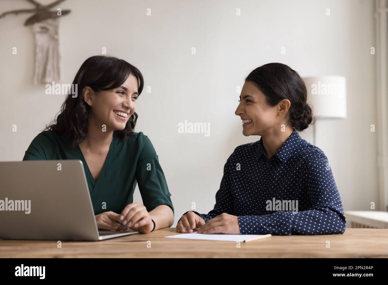 Les femmes multiethniques se sont bien amusées à s'asseoir au bureau sur leur lieu de travail Banque D'Images