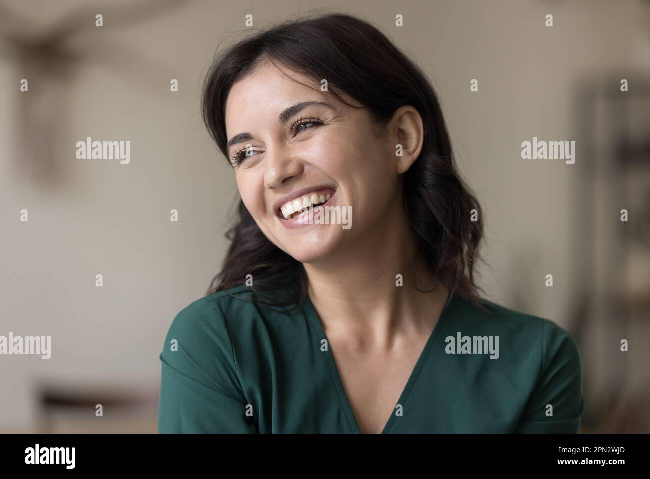 Portrait de la belle jeune femme heureuse regardant de côté poser à l'intérieur Banque D'Images