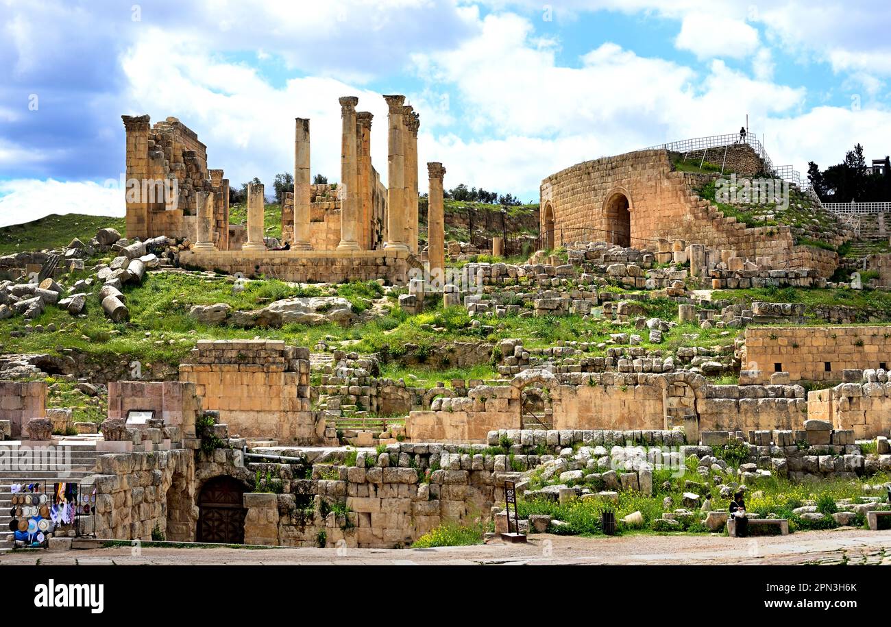 Ruines romaines antiques à Jerash, Jordanie, montrant le théâtre sud et les imposantes colonnes du sanctuaire de Zeus sur une colline herbeuse. Banque D'Images