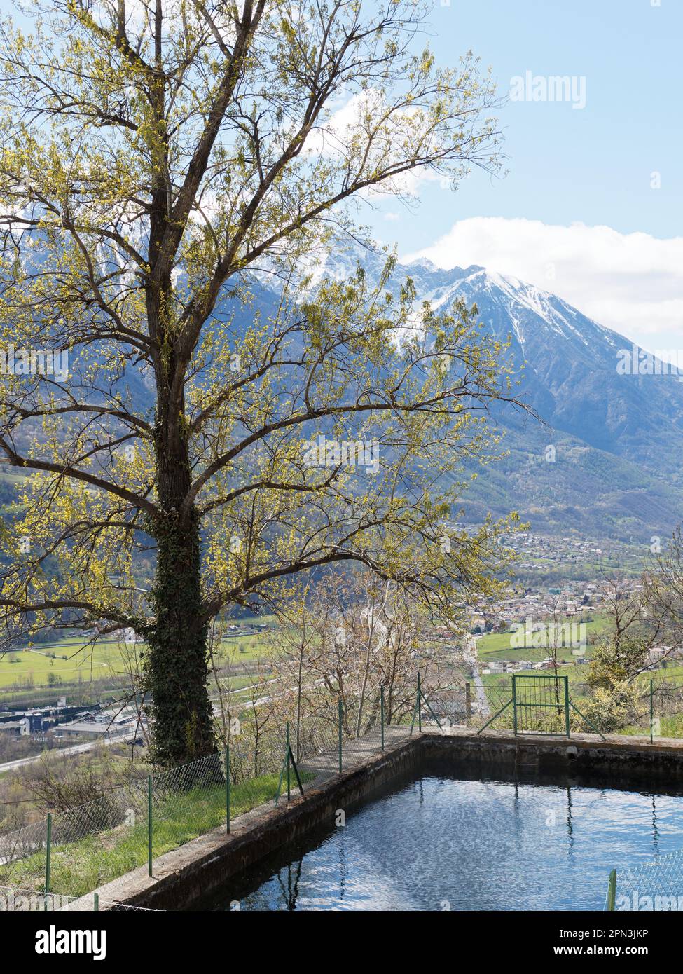 Réservoir de rétention d'eau dans le cadre du système de distribution d'eau dans un cadre alpin près de nus dans la vallée d'Aoste, Italie. Enneigé derrière. Banque D'Images