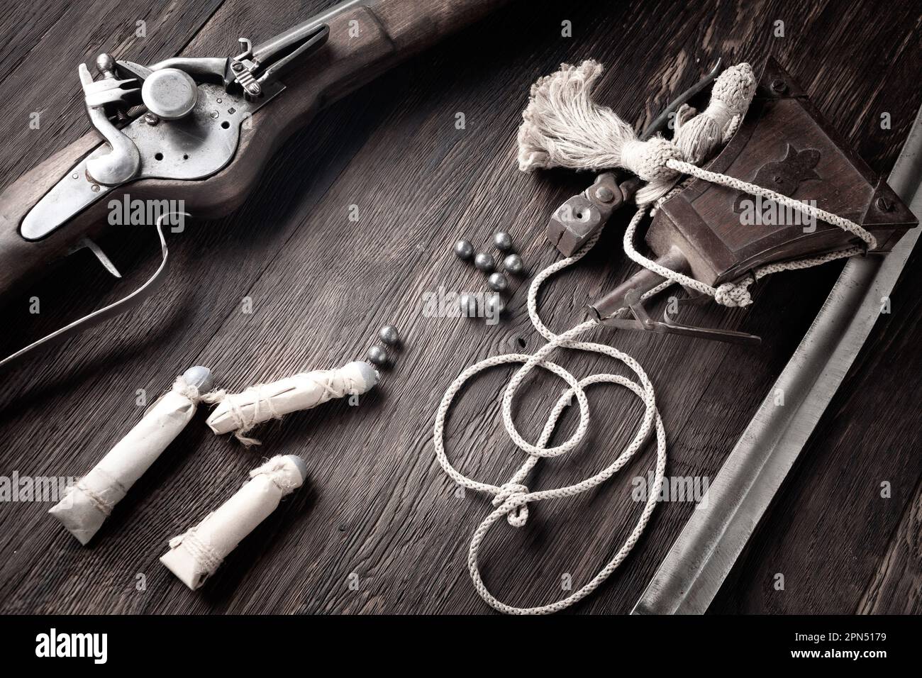Ancienne mousquet de flintlock avec ballon de poudre et balles LED sur le pont en bois. Banque D'Images