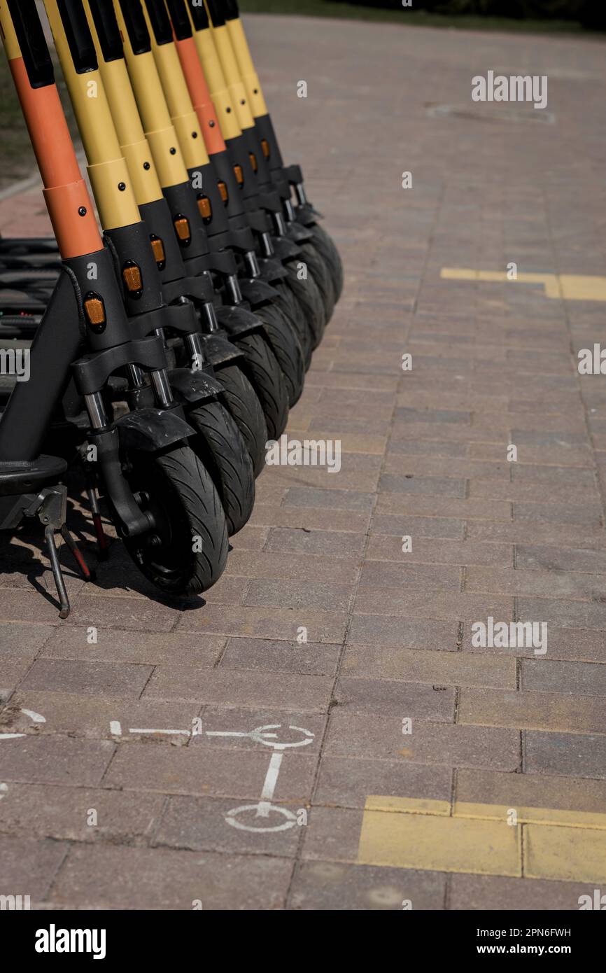 Transport urbain électrique: La rangée de lectures électriques pour faire du scooter des vélos avec des accumulateurs au centre d'une ville sur la chaussée Banque D'Images