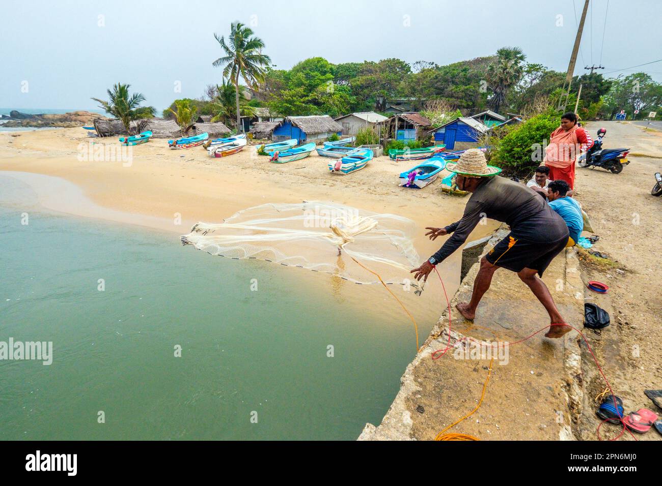 Pêcheur jetant un filet à partir d'un pont au-dessus d'une rivière au Sri Lanka Banque D'Images