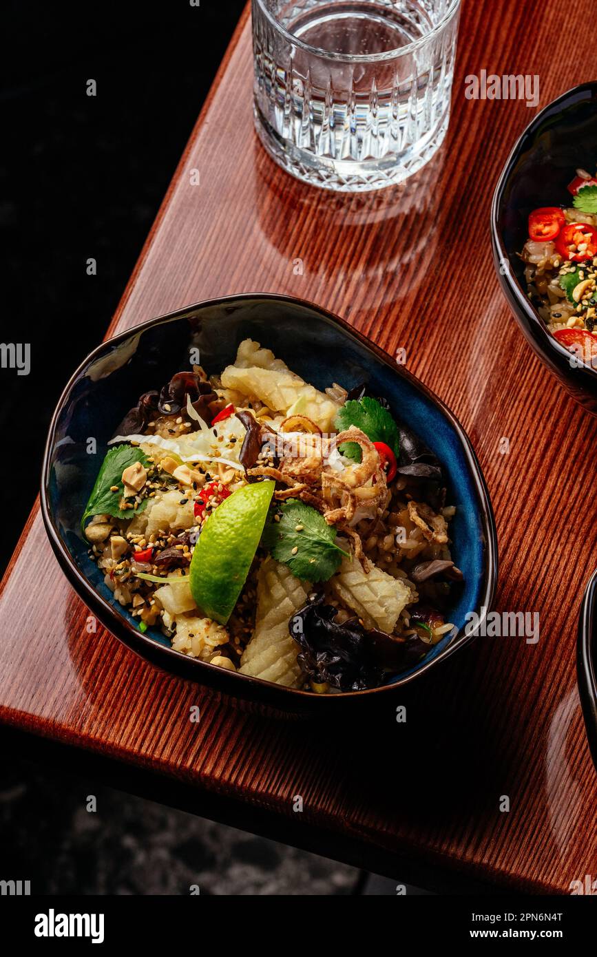 Riz chinois frit avec du calamar, des légumes et des herbes. restaurant Banque D'Images