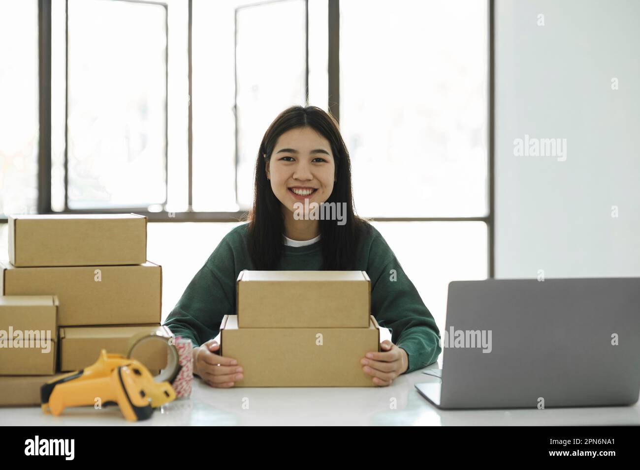 Femme en ligne propriétaire d'affaires tenant le colis et regardant le chamer Banque D'Images