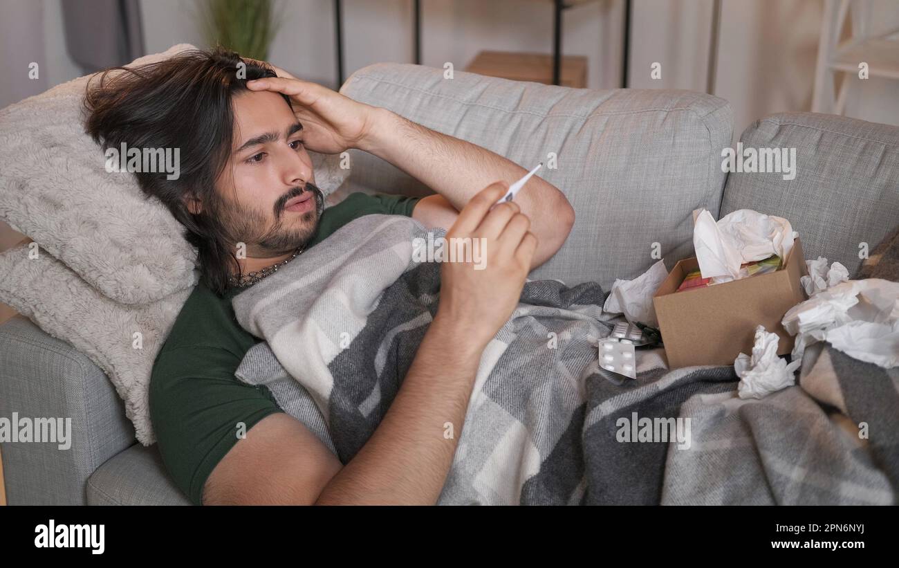 Grippe fièvre maladie température homme malade sur le canapé Banque D'Images
