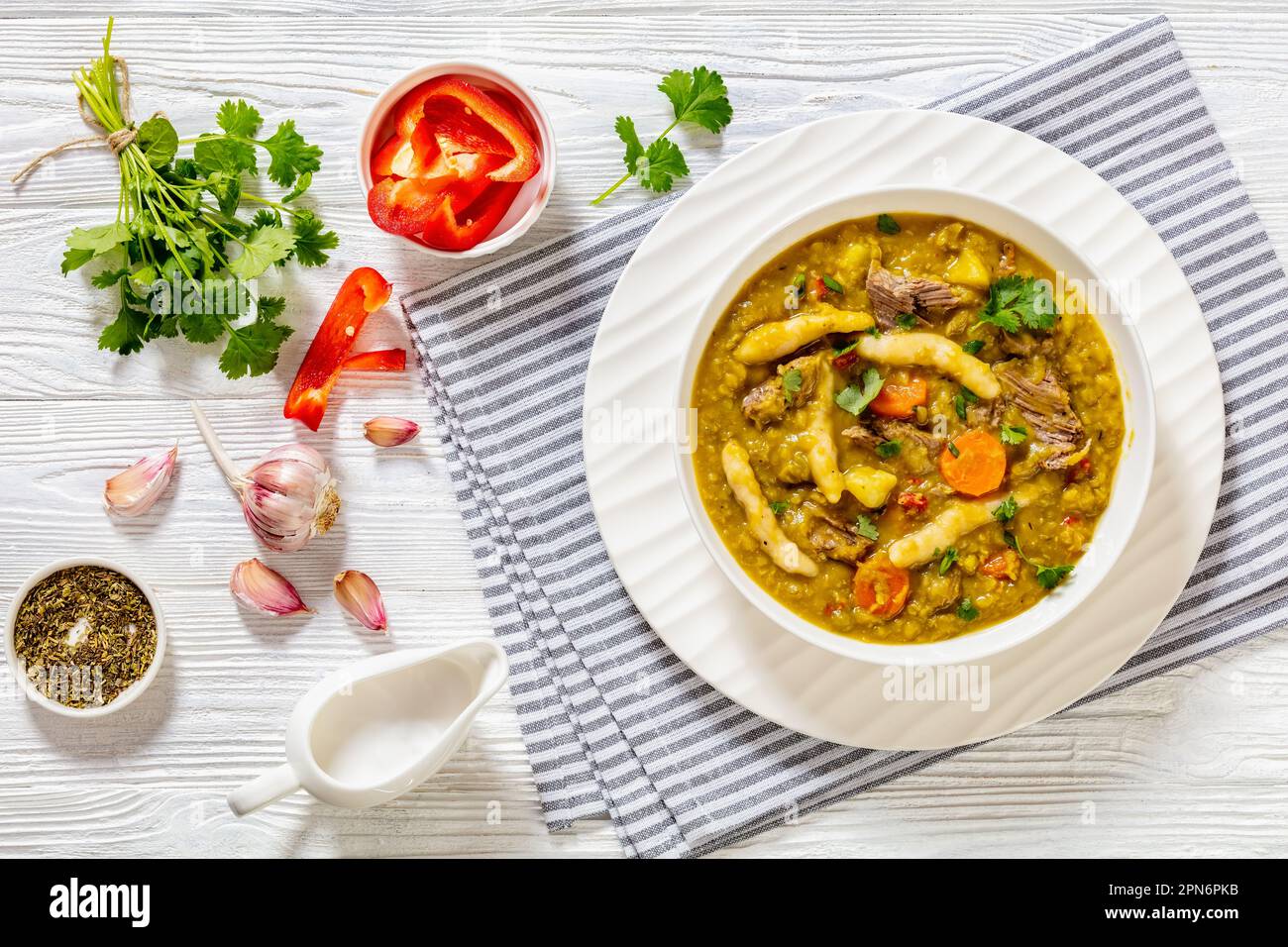 petits pois, soupe de petits pois avec boulettes, légumes et bœuf dans un bol blanc sur table en bois blanc avec ingrédients, cuisine jamaïcaine, plat, gratuit Banque D'Images