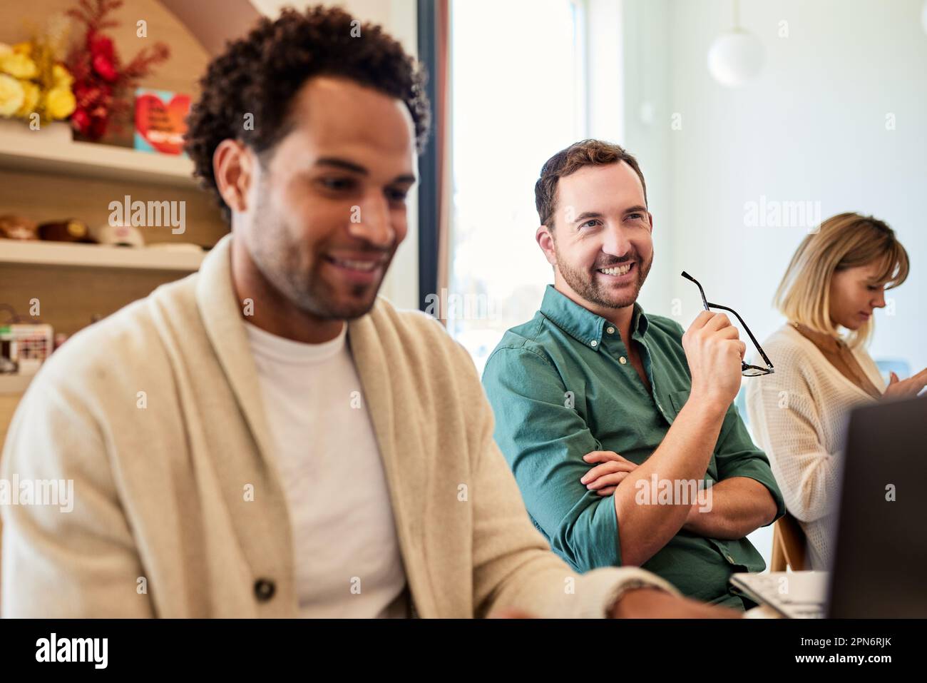 Homme d'affaires heureux assis par des collègues dans un café Banque D'Images