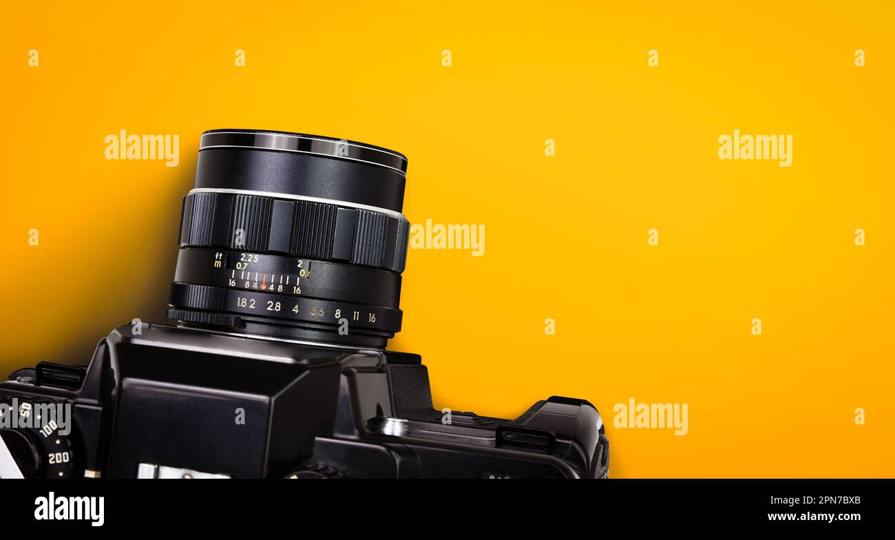 Vue de dessus de la caméra film vintage noire isolée sur fond jaune ou orange avec masque. Banque D'Images