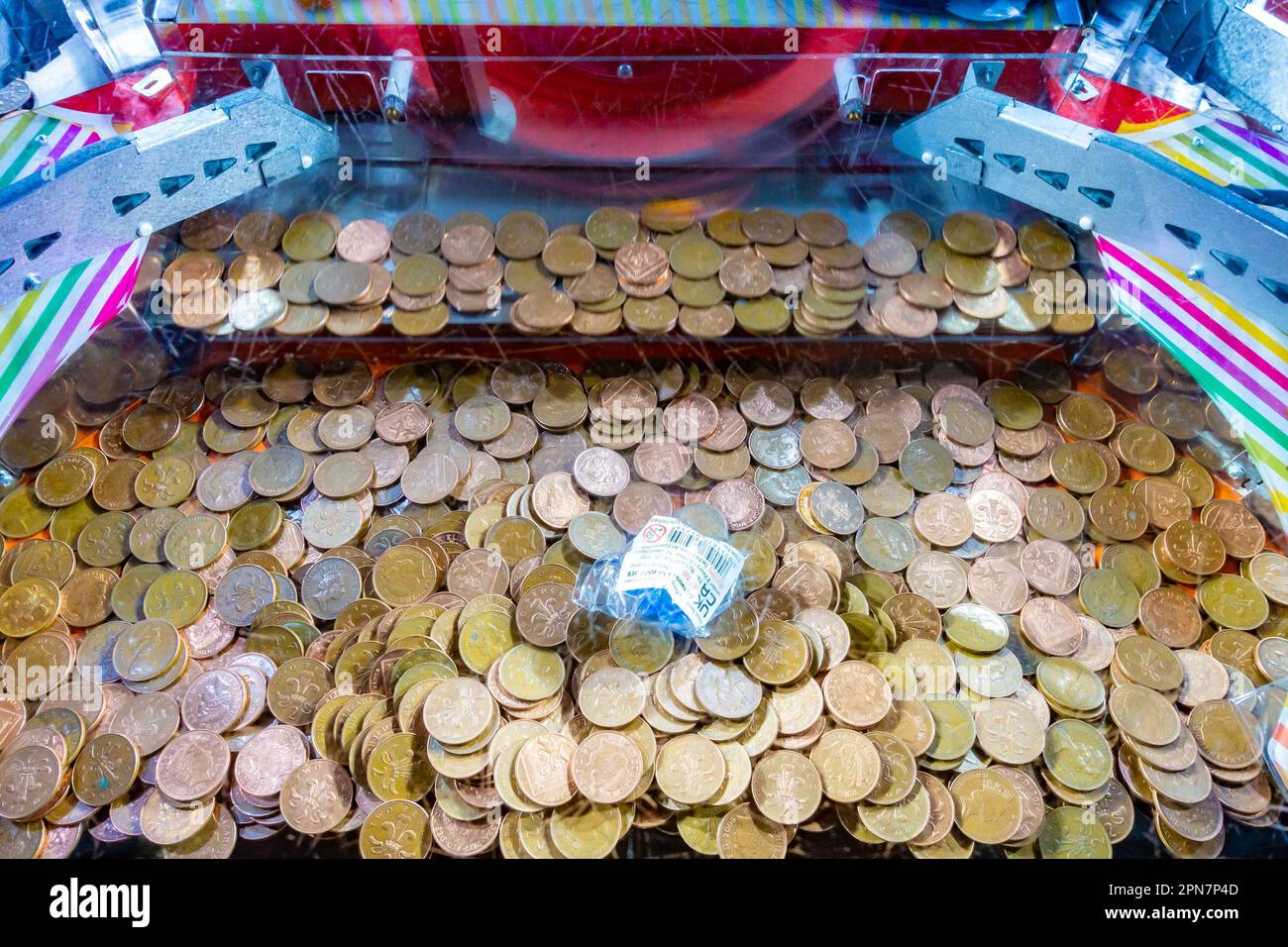 Vue rapprochée de deux pièces de clôture dans une machine de chutes de penny dans une arcards d'amusement Banque D'Images