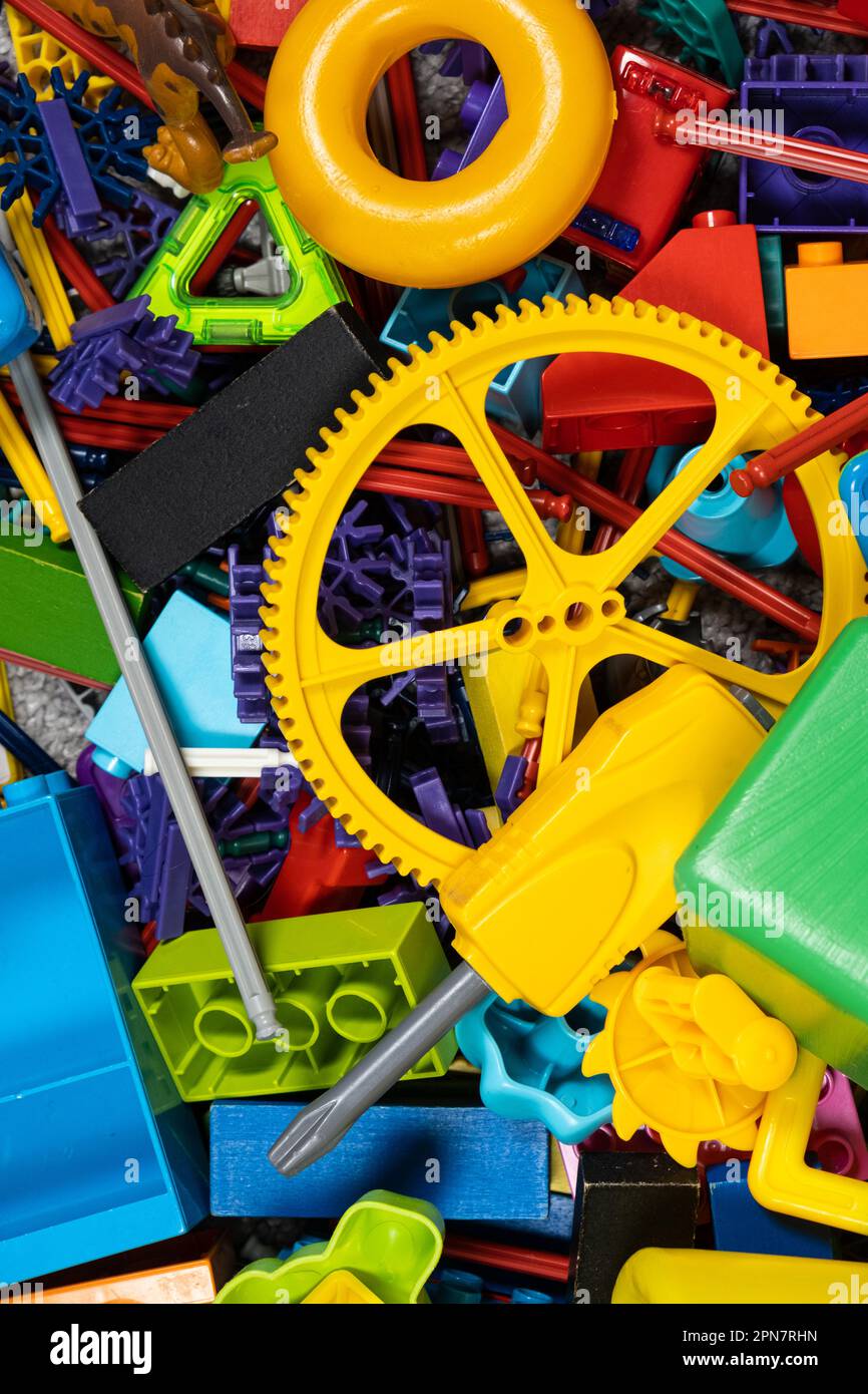 Une abondance de jouets dans la chambre des enfants, beaucoup de pièces en plastique multicolores de designers, pièces de rechange pour jouets, figurines et cubes. Banque D'Images