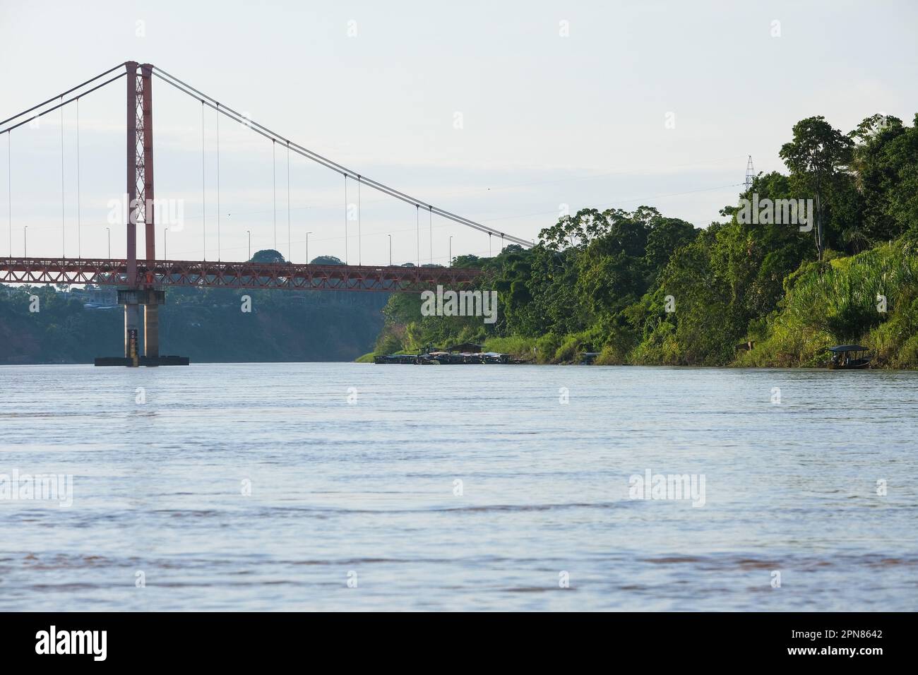 Puerto Maldonado Billinghurst pont rouge avec rivière Amazone, ciel bleu, fond de forêt au Pérou. Foyer sélectif de la rivière. Espace ouvert. Banque D'Images