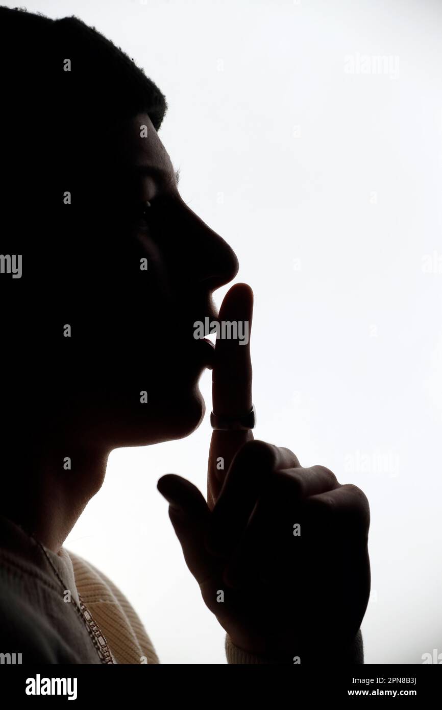 Silhouette d'un homme faisant signe silencieux. Banque D'Images