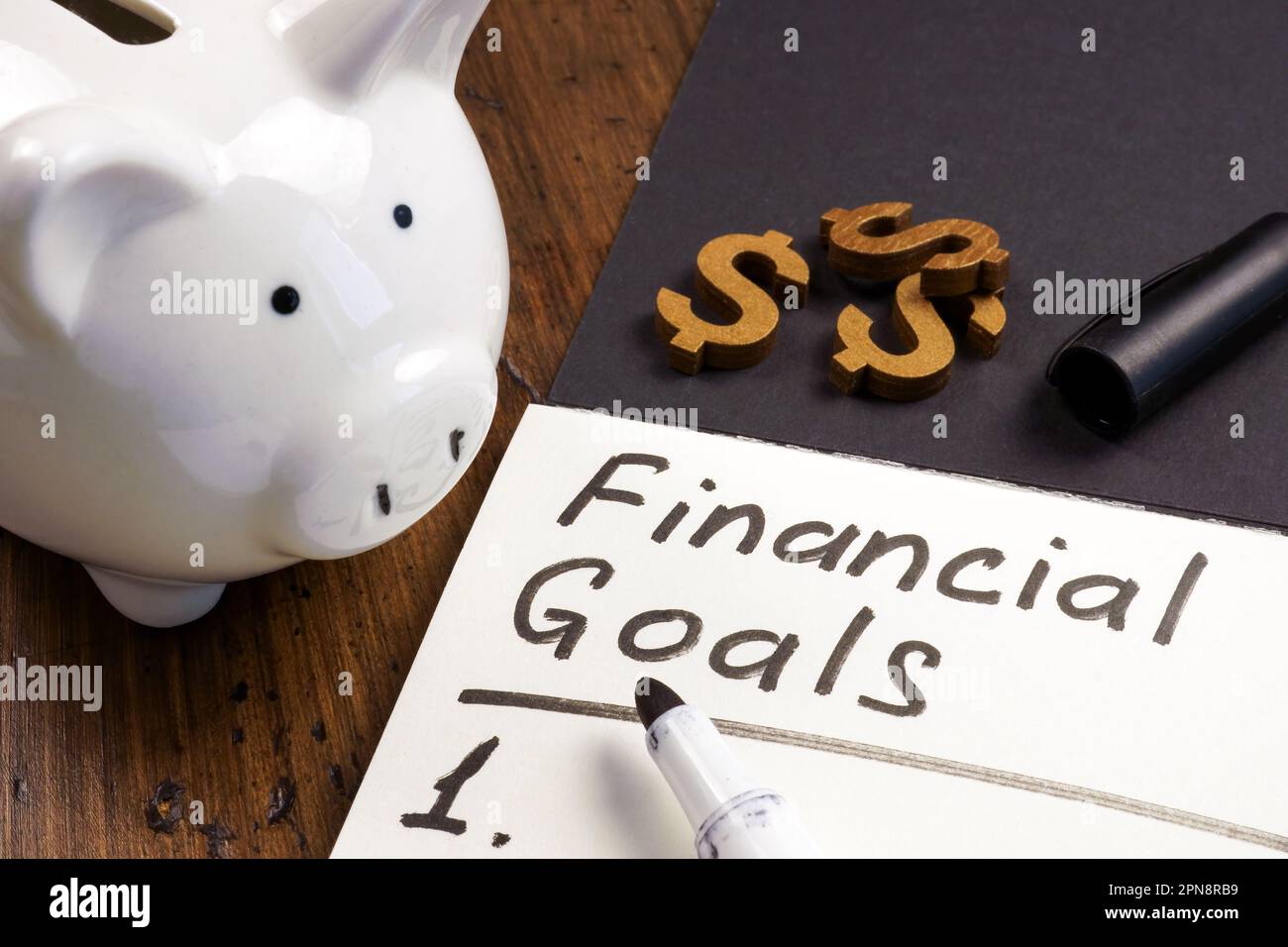 Banque de piggy et bloc-notes ouvert avec inscription objectifs financiers et liste. Banque D'Images