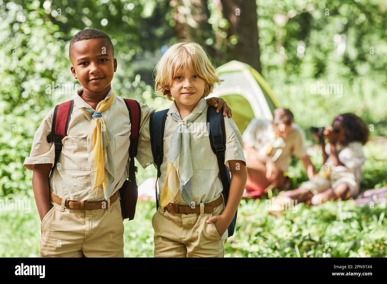 Portrait à la taille de deux scouts de garçon regardant l'appareil-photo tout en campant avec le groupe d'école, l'espace de copie Banque D'Images